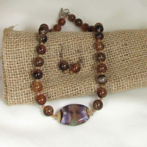 Handmade bead framed with agate beads makes this limited addition necklace and earrings a classic